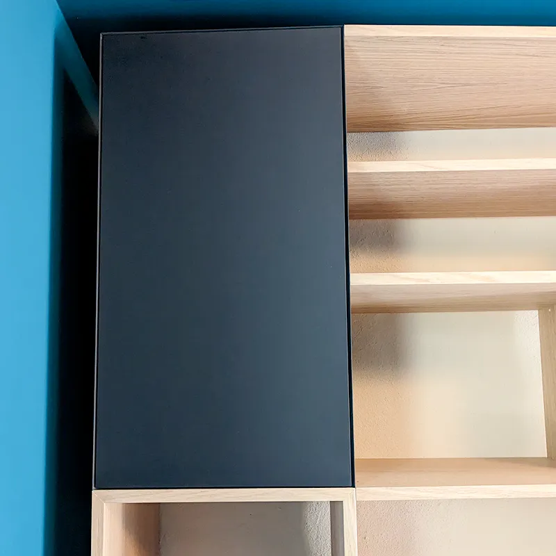 Vue d'une bibliothèque sur mesure composé de blocs dont un meuble haut fermé